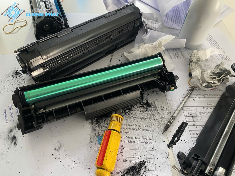 Các linh kiện bên trong hộp mực máy in Canon đang được tháo rời để vệ sinh và nạp mực: Trống (Drum), Trục từ, Gạt mực và bột mực thải.